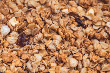 Useful and tasty muesli with nuts, rasins and flakes. Selective focus macro shot with very shallow depth of field. Healthy and vegetarian lifestyle