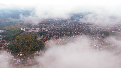 City through the clouds. Aerial view of autumn lanscape