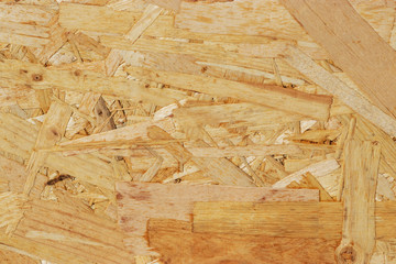 Pressed wood board texture: particle board. Production of natural materials for the construction of structures. Bright sunshine.
