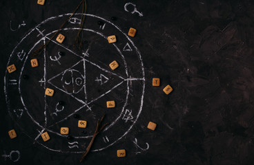 Open old book with magic spells, runes, black candles on witch table. Occult, esoteric, divination...