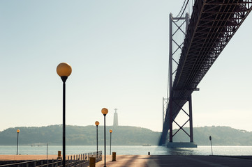 Beautiful promenade and 25th April Bridge on Tejo river in Lisbon, Portugal. Summer landscape.