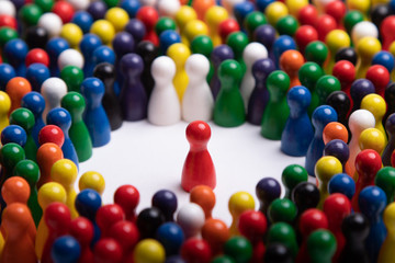 wooden red figurine surrounded by a large group, standing for speaker or critical situation