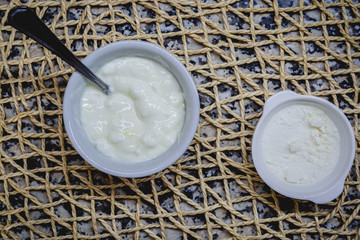 Sweet Yoghurt in a small cup with natural sweetener on a plate mat.