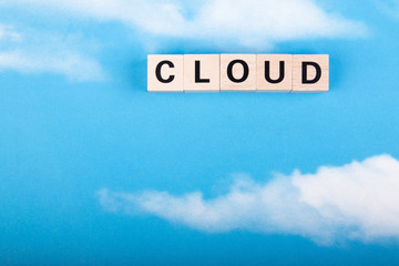 word cloud made of wooden blocks, sky with clouds as background
