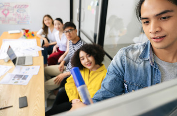 Group of Asian businessman writing on whiteboard during business presentation business people team meeting in modern office working design planning and ideas concept