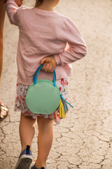 Little girl holding a blue purse