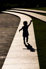 Silhouette of a little girl running on a path