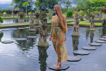 Fototapeta na wymiar Beautiful girl in the water temple of Inlonesia. Bali.