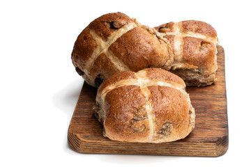 Easter wholemeal hot cross buns on wooden board isolated on white