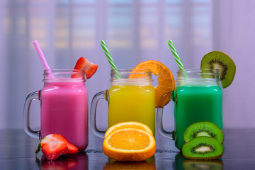jugs of juice with different colorful smoothies, healthy drink with berries and fruits, healthy lifestyle