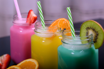 jugs of juice with different colorful smoothies, healthy drink with berries and fruits, healthy lifestyle