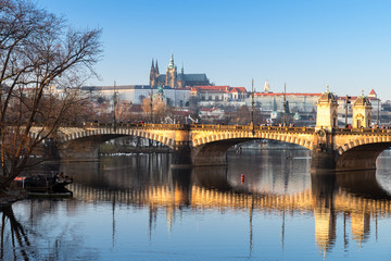 The Legia bridge is reflected in the water of the Vltava River against the background of St. Witta in winter Prague