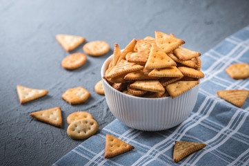 Fresh cheese cracker biscuits with herbs on dark background