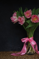 Pink Tulips in vase and ribbon dark background