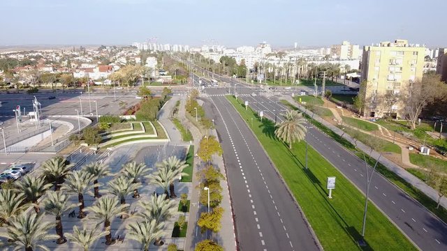 The drone camera descends in the direction of two cyclists riding a bike path in Beer-Sheva