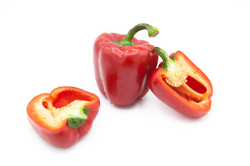 Ripe fresh organic peppers and two halves of pepper in dew drops isolated on a white background