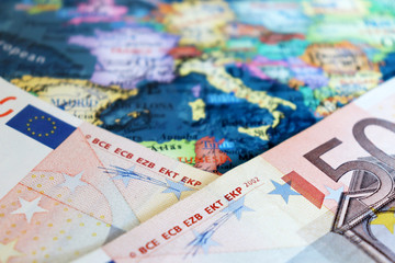 Euro banknotes on the map of Europe, selective focus. Concept for european economy, eurozone...