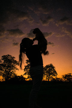 Ni&ntilde;a cargando a perro peque&ntilde;o