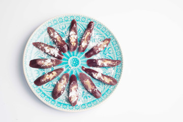 churchkhela sprinkled with icing sugar on a plate with oriental-style ornament
