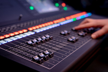 Close up of audio mixing desk with blurred lights