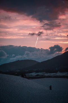 fotografia de dunas con monta&ntilde;as y un aterdecer de fonfo