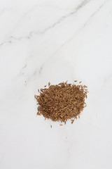 Pile of cumin seeds captured from above isolated on white. Seeds of caraway, also known as meridian fennel and Persian cumin. Aromatic carminative. Concept of health and food