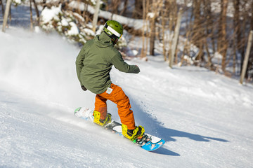 Snowboarder having fun riding hill at ski resort