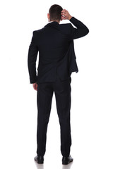 Rear view of a confused businessman scratching his head