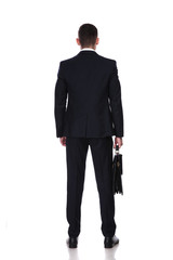Obraz na płótnie Canvas Rear view of confident businessman holding briefcase