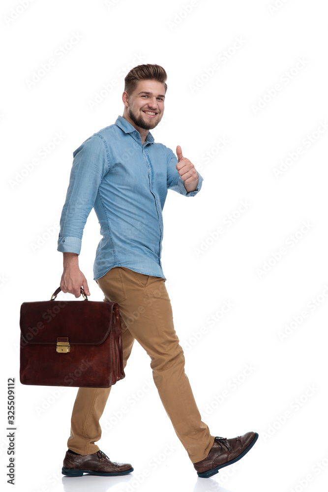 Wall mural Side view of a positive casual man gesturing ok