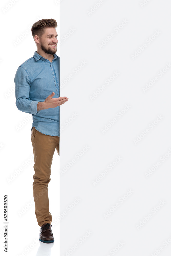 Canvas Prints Happy casual man smiling and presenting an emplty billboard