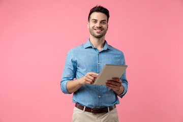 happy young guy smiling and holding tab