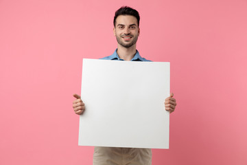happy young guy smiling and holding empty board