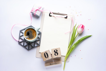 Composition with a tulip, coffee and March 8 wooden calendar on a white background with space for text. Flat lay. 8 March, International Women's Day.