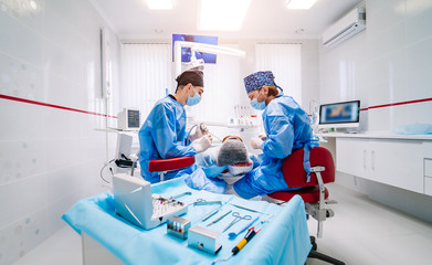Obraz premium Stomatological instrument in dental clinic. Operation, tooth repairing. Medicine, health, stomatology concept. Doctor in mask. Selective focus.