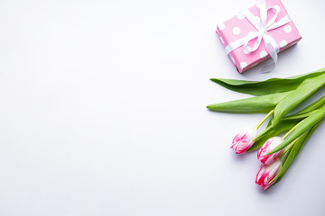 Tulips and gift box on white background, space for text. Flat lay. 8 March, International Women's Day.  Valentine's Day.