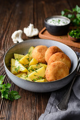Fried cauliflower and cheese croquettes with boiled potatoes and sour cream dip