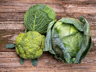 Three kinds of cabbage on old wooden background.