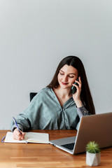 Young attractive girl takes calls in the office