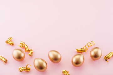 The pink background for Easter, with space for text, is decorated with confetti and Golden eggs at the bottom, with copy space. The Concept Of Easter.