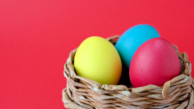Colorful easter eggs in a basket on a red background. Easter concept background.