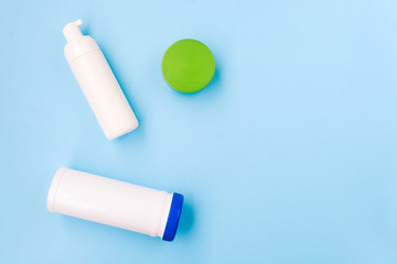 Cosmetic products on a blue background. Face foam, cream and a napkin can. Body and skin care. Beauty salon, spa concept.