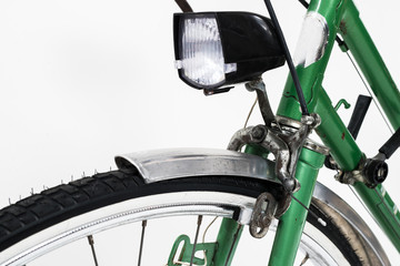An old retro looking green vintage city bicycle for women, isolated o white background. Detail of...