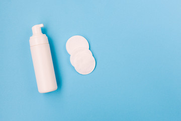 Foam for face and cotton pads. Face and body care. Cosmetic products on a blue background. Female and male beauty.