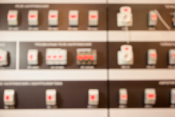 Background of blurred factory electrical devices. Abstract defocused machinery backdrop with red lights.