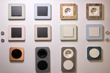 Various switchers and sockets texture. White wall with rosettes.