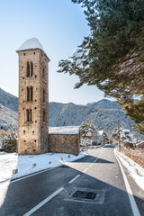 Catholic Church in Andorra from the Romanesque period next to the road with the snowy landscape.