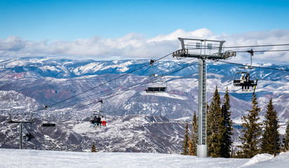 Skiers and snowboarders ascend the Elk Camp chairlift at the Aspen Snowmass ski resort, in the...