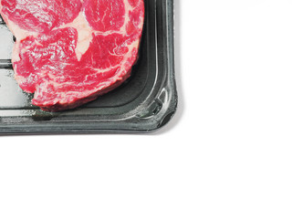 Two fresh premium rib eye steak in a vacuum pack package on a white background.
