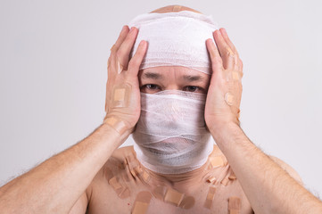 Portrait of sufferer male with bandaged head feeling bad